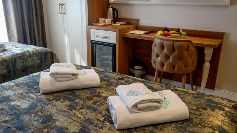 Nilüfer Otel triple oda yatak düzeni, havlu seti ve konforlu koltuk